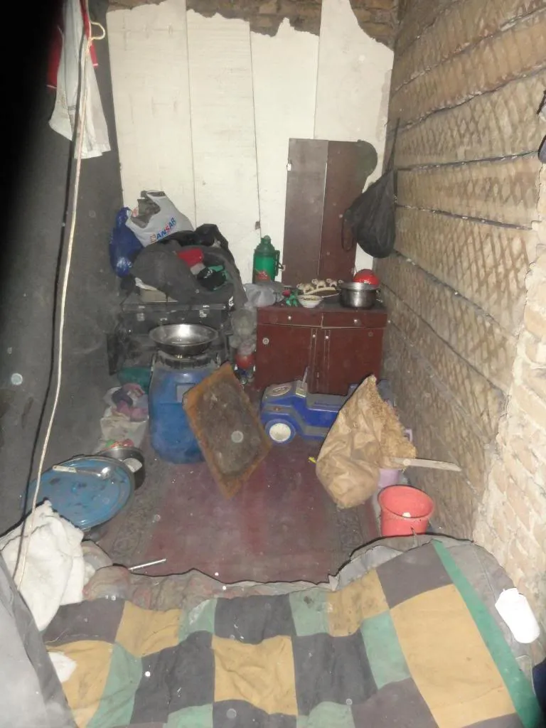 De oude, onverwarmde gang waar de moeder en haar drie zonen woonden